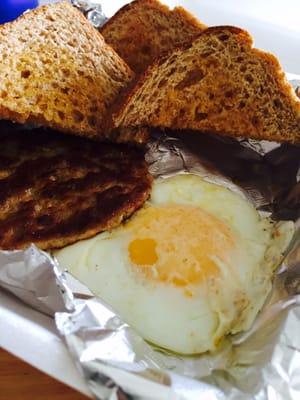 Eggs over easy with sausage and wheat toast