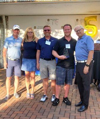 Ned Cooke, Dianne Wiedemann, and John Wiedemann honoring the Carrier s of the Year at JMWSONS annual Golf Event 2022.