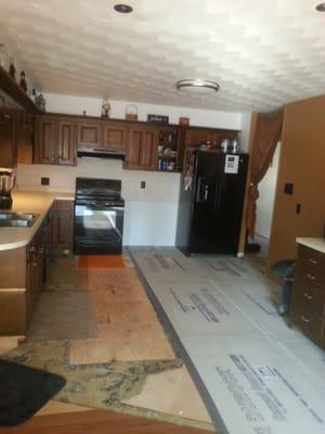 Kitchen being completely gutted for remodel and concrete board being installed to worn out damaged flooring