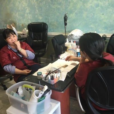 Nail technicians eating sunflower seeds and spitting them onto the work area. Sunflower seeds on the floor.