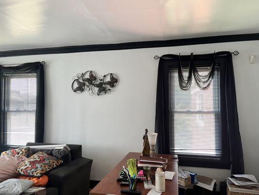 Distant view of living room walls and crown molding painted.