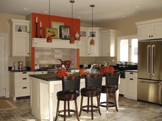 Painted  cabinets with varying height cabinets and a hearth hood