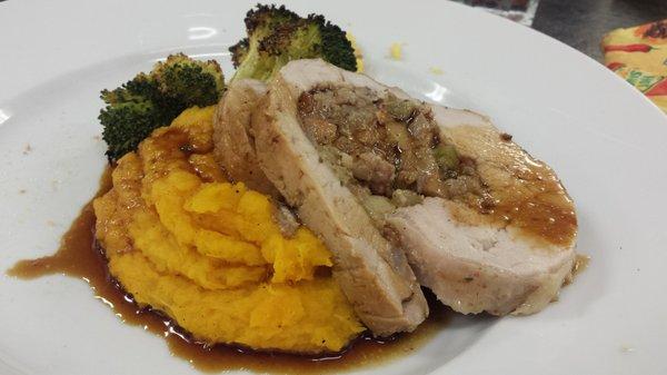 Pork tenderloin with cornbread stuffing, butternut squash mash, smoked rub broccoli, and an apple cider reduction glaze.