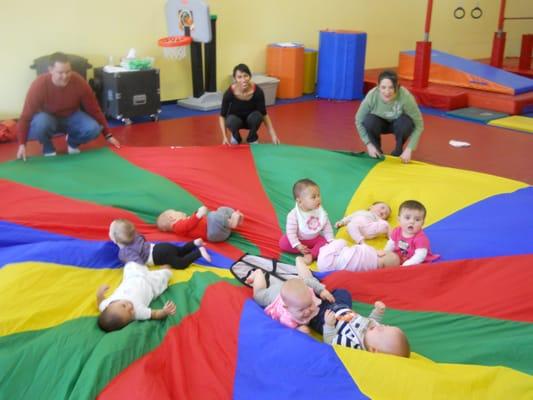 Our youngest class, Bugs (4-10 months) having fun on the parachute!