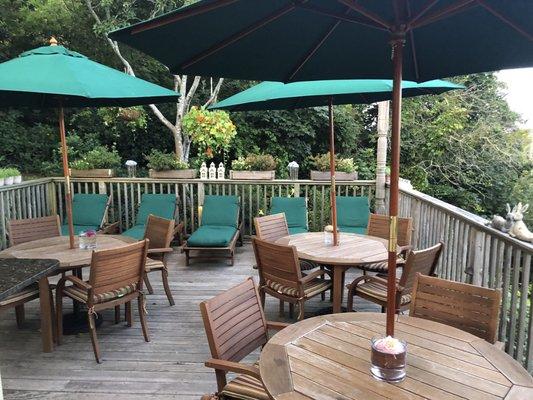 Outdoor deck with sun lounge chairs, dining area and an amazing view of bay.