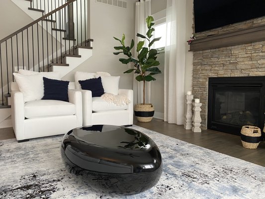 Accent chairs with white performance fabric and modern, black, resin coffee table.