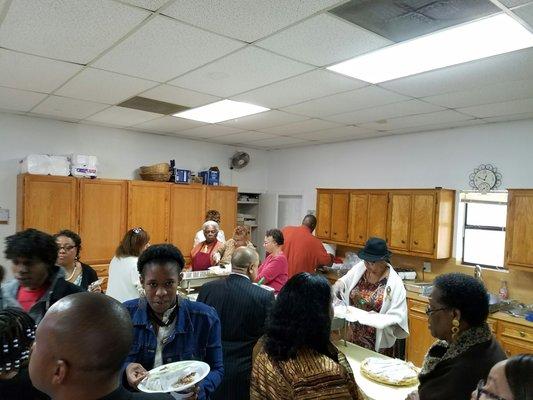 Kitchen staff helps serve.