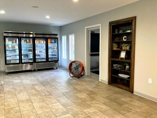 Panning left from the front door- a built in book shelf with some decor and a grab and go fridge/freezer.