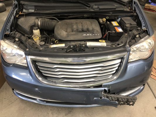 Chrysler town & country in need of a new bumper, grille and radiator support.