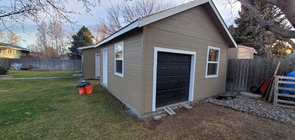 Nice shed with a garage door for driving ride on mower into it.