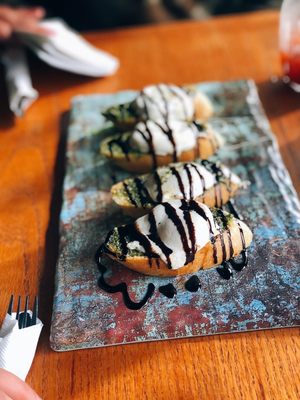 Bruschetta with pesto, mozzarella, marinated Roma slices (under the cheese) and balsamic drizzle