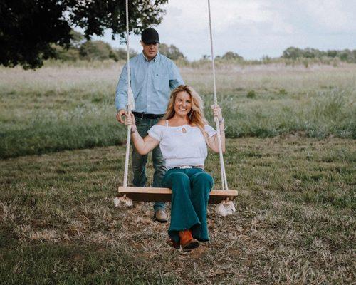 Engagement photographer poses couple on outdoor swing in Lincolnton, NC