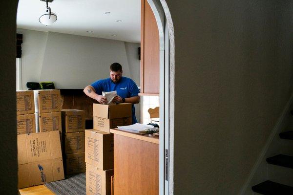 Crew member packing household goods for a residential move. Reynolds Transfer & Storage, Inc.