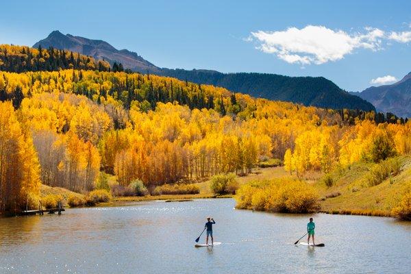 Golden fall colors provide a spectacular backdrop for an afternoon SUP.