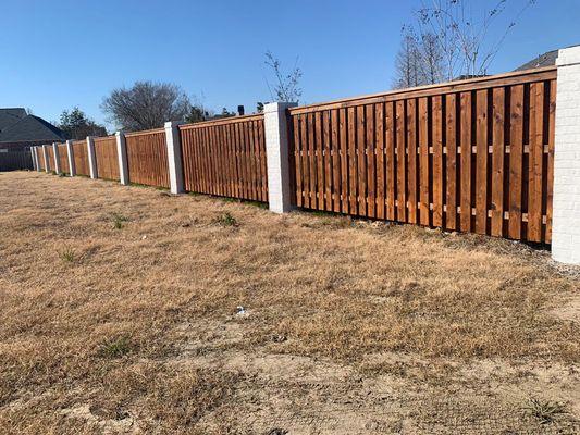 Painted brick outside and stained fence.