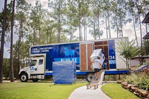 Blue ox moving truck with movers loading furniture.