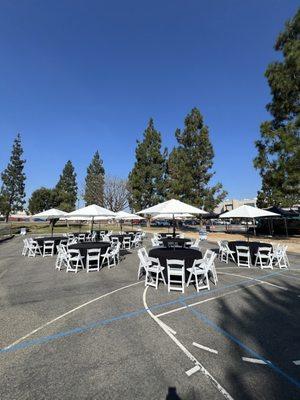 9' market umbrellas, 120" round linen, 60" round tables and white resin padded chairs