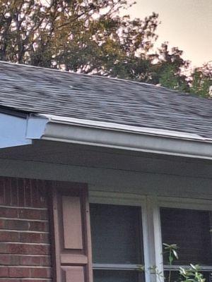 Leaf filter laying on top of gutter. Not installed underneath roof.