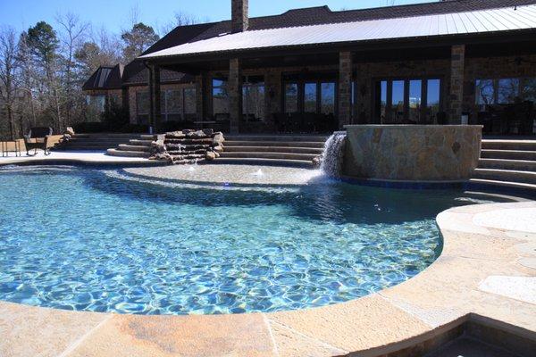 A Trinity Valley Pools custom in ground swimming pool, spa, waterfalls, infloor cleaning and circulation system and Pentair equipment.