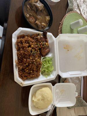 Jollaf rice and chicken in the container, fufu to the right and the goat soup on the left.