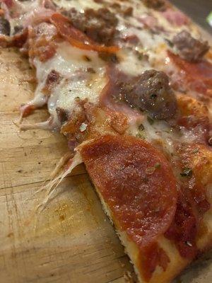 Yummy thin crust Godfather (meaty) pizza with great sauce.