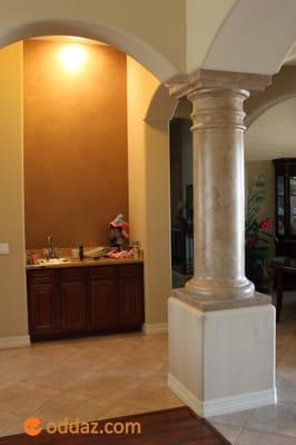 Now that is better. Metallic bronze plaster on the wall in the wet bar and a natural travertine look for the column...