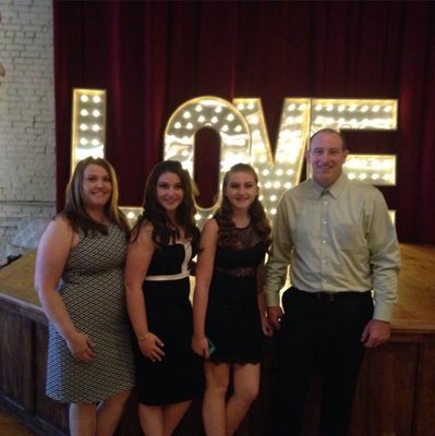 SMiles all around for this happy family posing in front of our lighted love letters we rent for events and weddings.