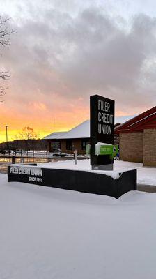 Filer Credit Union sign covered in snow at sunset.