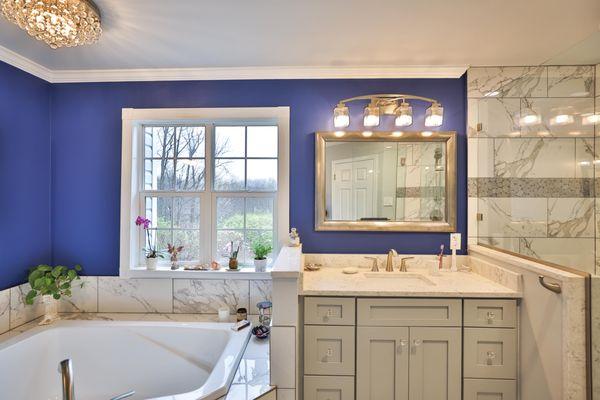 Master bathroom remodel in Frederick with corner bathtub & marble lined tiles