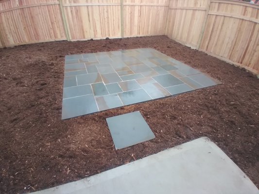 New cedar fence, restored boulder wall, and Bluestone patio by Bianco's Landscaping & Masonry.