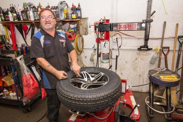 Tire Shop in Floyds Knobs, Indiana. An employee mounting a tire on the rim for customer at Faulkenburg Automotive.