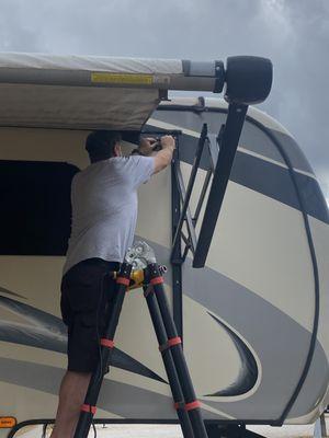 Repairing the electrics wires that power the LED lights on an awning.