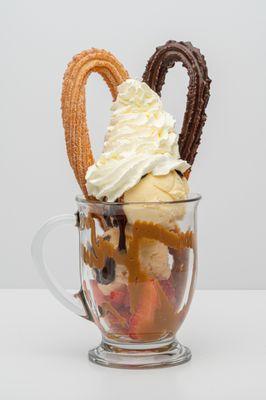 Churro Split, fresh strawberries, vanilla ice cream, chocolate and dulce de leche sauce, whipped cream and 2 churros.