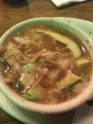 Bowl of chicken tortilla soup with a side of avocado