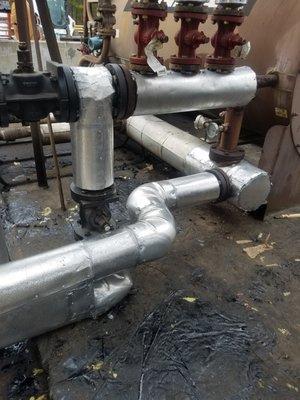 Pipes insulated and covered with metal jacketing to prevent exposure to weather.