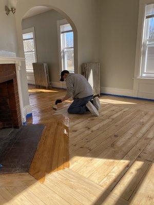 Coating hardwood floor with a satin finish.