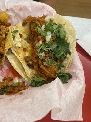 Tacos Al pastor with grilled onions.