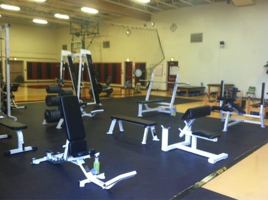 Free weight section, basketball court in the background.