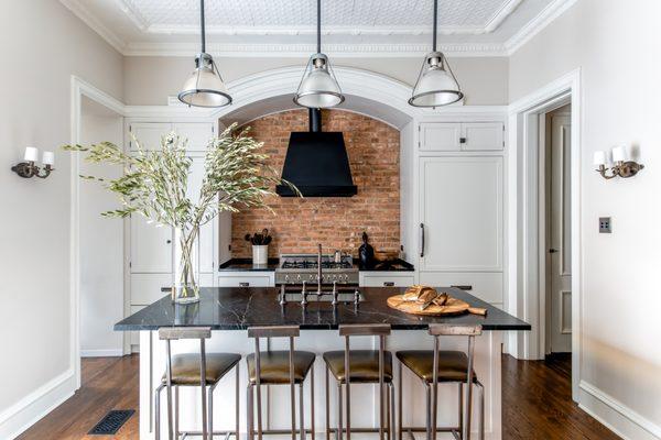 A custom kitchen with exposed brick and high-end appliances.