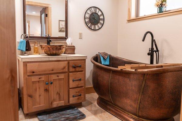 A unique copper tub serves as the center piece in this bathroom remodel by Lawson Construction.