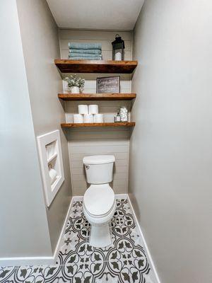 Bathroom remodel - New tile, shiplap accent wall, floating shelves, toilet paper niche, new trim and wall color.