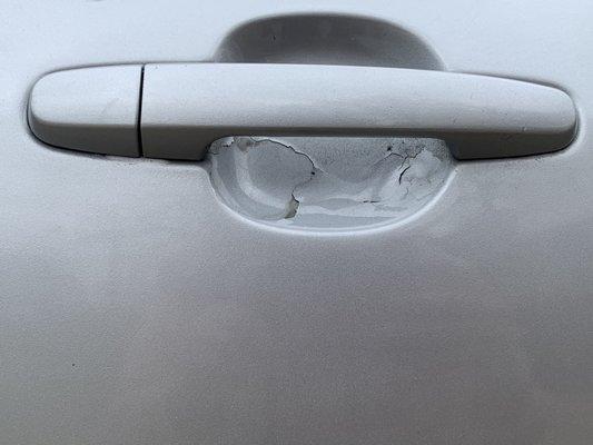 Chipped paint on rear passenger side door handle.