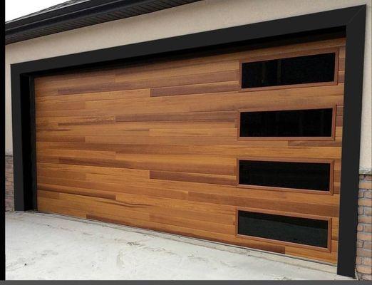 Double steel insulated garage door with wood look finish.