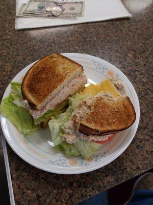 Tuna fish lettuce tomato slice of American cheese on butter rye toast.