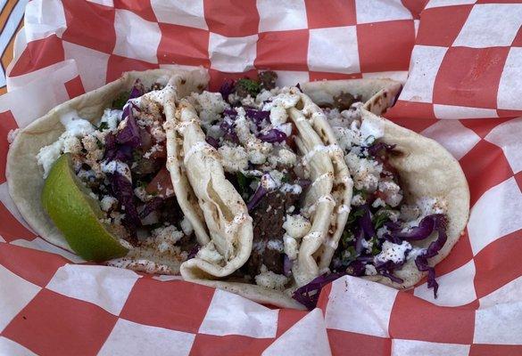 Carne asada, slaw, cojita cheese,  and a secret white sauce.  Flavor bomb explodes in your mouth.