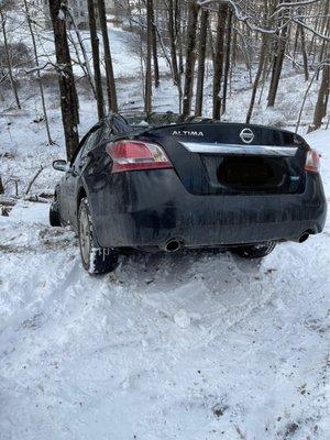 Car that slid over hill into ditch stopped by tree