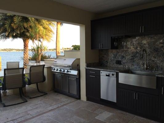 This outdoor kitchen has everything!  A grill with a side burner, a sink, wine rack, dishwasher and they still have plenty of counter space!