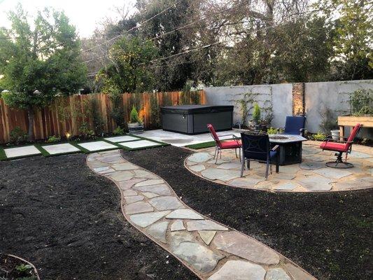 New concrete slabs, cedar fence, back wall with stucco and tile accents.