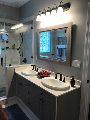 Bathroom remodeling involving new cabinetry, sinks, mirror, lighting, custom tile, flooring, glass enclosure, faucets, painting, etc.