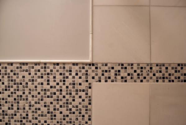 Bathroom wall tile design detail: mosaic, marble tiles and edging.